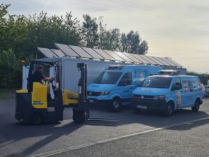 Jude's Ice Cream - 2 vans and forklift next to solar powered cold storage